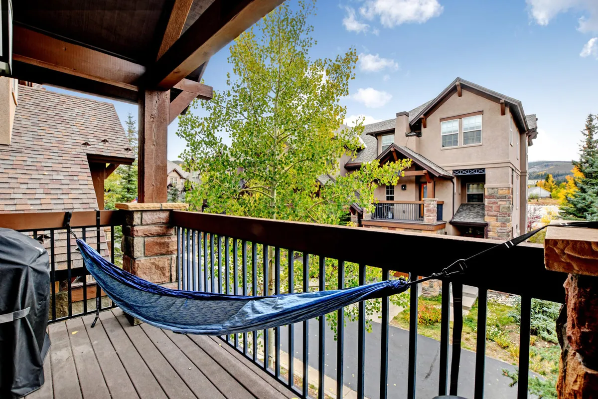 A tranquil outdoor balcony featuring a hammock, breezy afternoons, and lush green trees. The space offers a relaxing retreat for reading, socializing, or simply enjoying nature—an ideal spot for family downtime or quiet moments together.